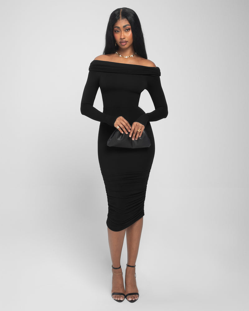 Model is posing in Shapey Off Shoulder Ruched Midi Shapewear Dress - Black