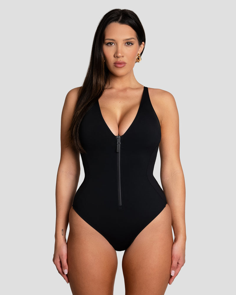 Size M Model wears Cheeky Plungey Zip One Piece Shapewear Swimsuit - Black front view
