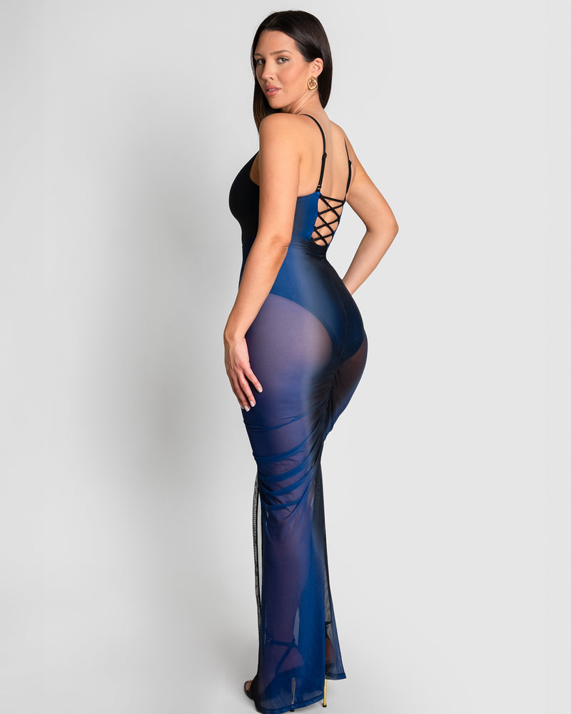 Model is wearing Ruched Sheer Side Slit Maxi Skirty - Midnight Ombre and matching color one piece swimsuit back view