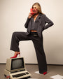 Model is posing in Swuity Medium Rise Relaxed Wide Leg Pant - Graphite and matching blazer side view
