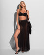 Full body front view of model wearing Ringy Sheer Slit Skirty - Black paired with bikini top 