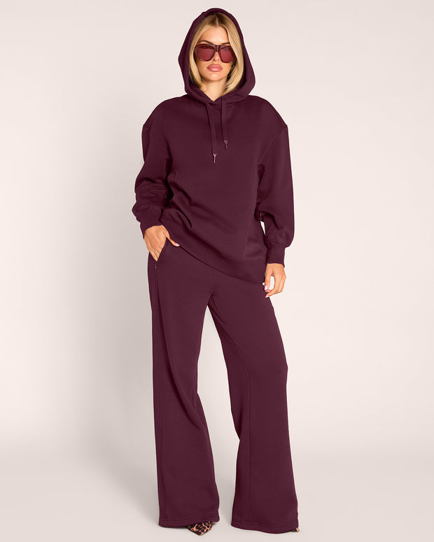 Full body front view of model wearing Convertible Fleecey - Garnet witih hood on