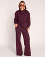 Full body front view of model wearing Convertible Fleecey - Garnet witih hood on
