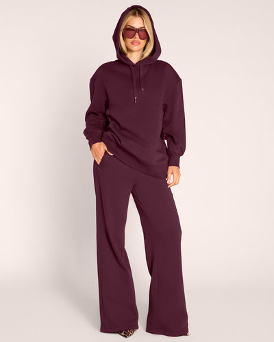 Full body front view of model wearing Convertible Fleecey - Garnet witih hood on
