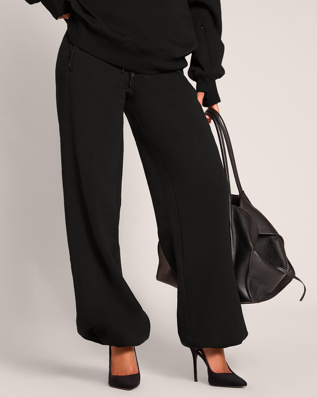 Model wearing Fleecey Wide Leg Pull On Pant - Black with the ankles cinched 