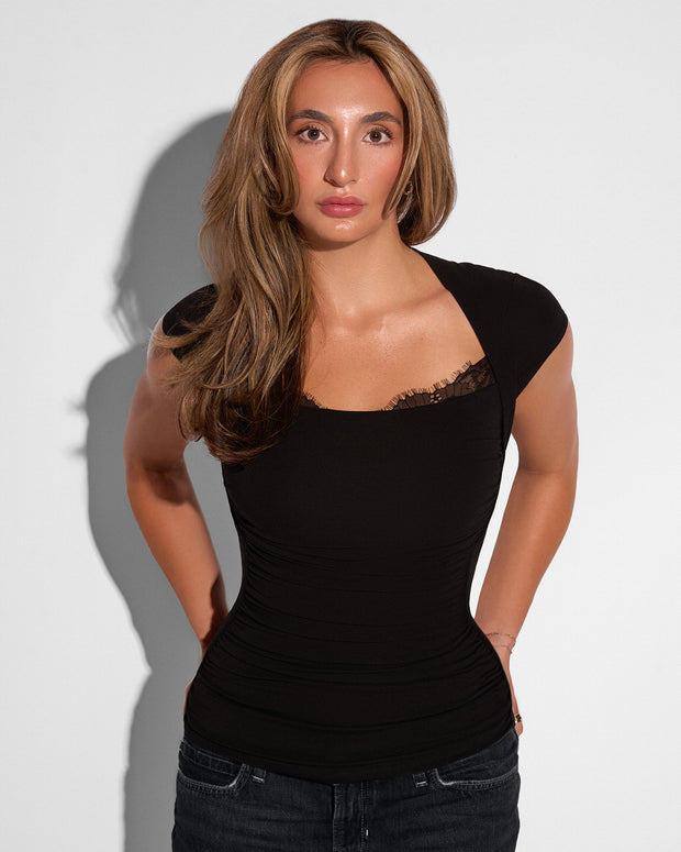 Model posing in Shapey Ruched Short Sleeve Top - Black untucked 
