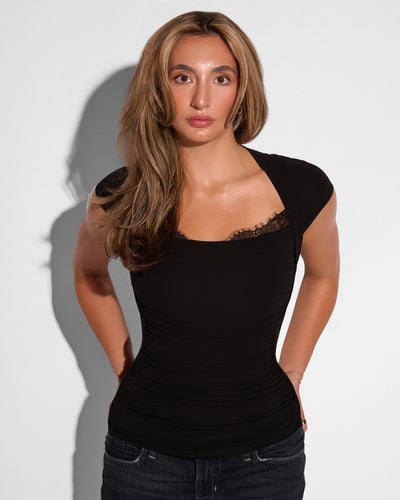 Model posing in Shapey Ruched Short Sleeve Top - Black untucked 