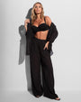 Model in Seersucker Gauze Flowy Shirt - Black paired with bikini top and matching pants